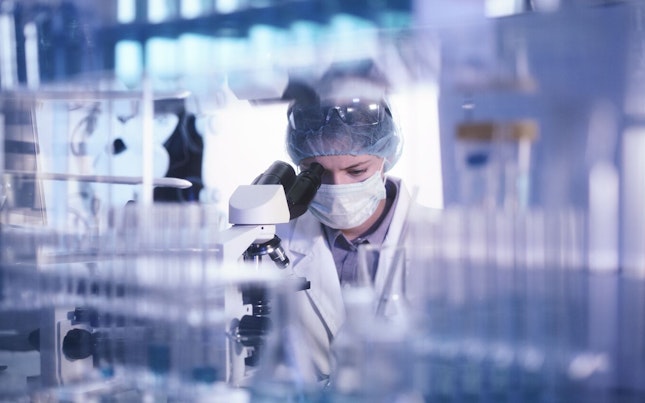 Microbiologist Studying Bacteria with Microscope